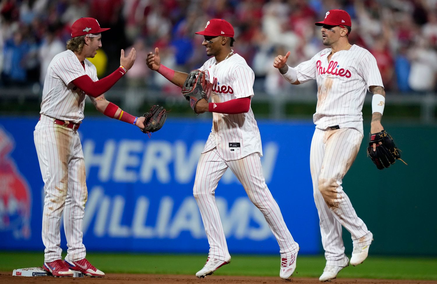 Phillies players Bryson Stott (left), Johan Rojas (center) and Nick Castellanos celebrate a Game 1 win in the NL wild-card series.
